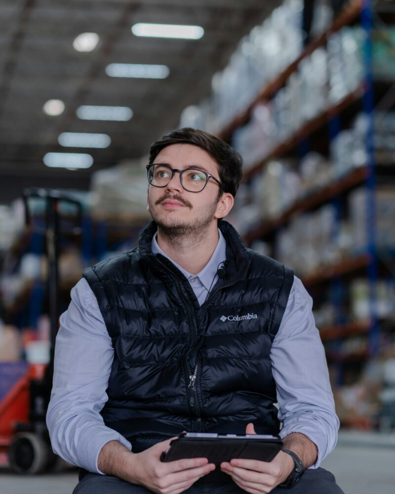 Coordinador de bodega revisando inventario con tablet en almacén logístico